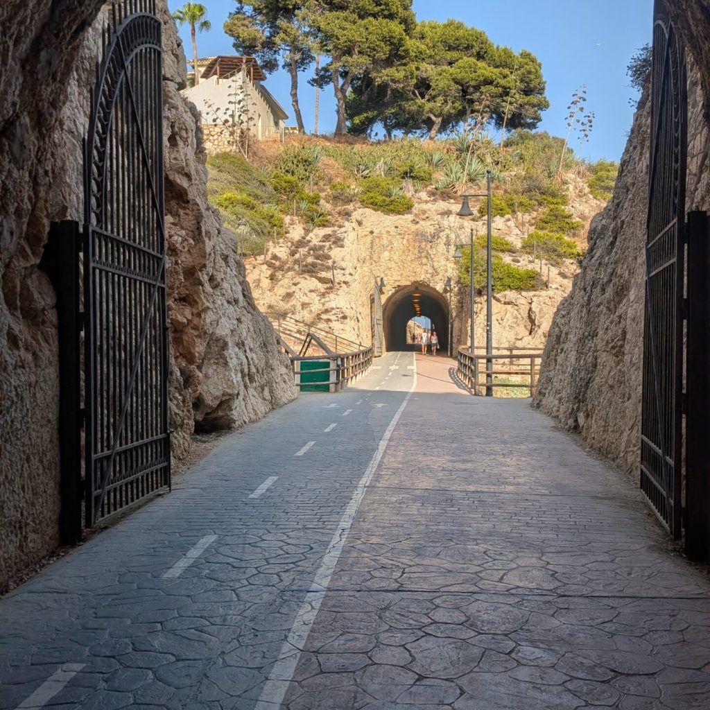 Looking out of a stone tunnel at a road ahead
