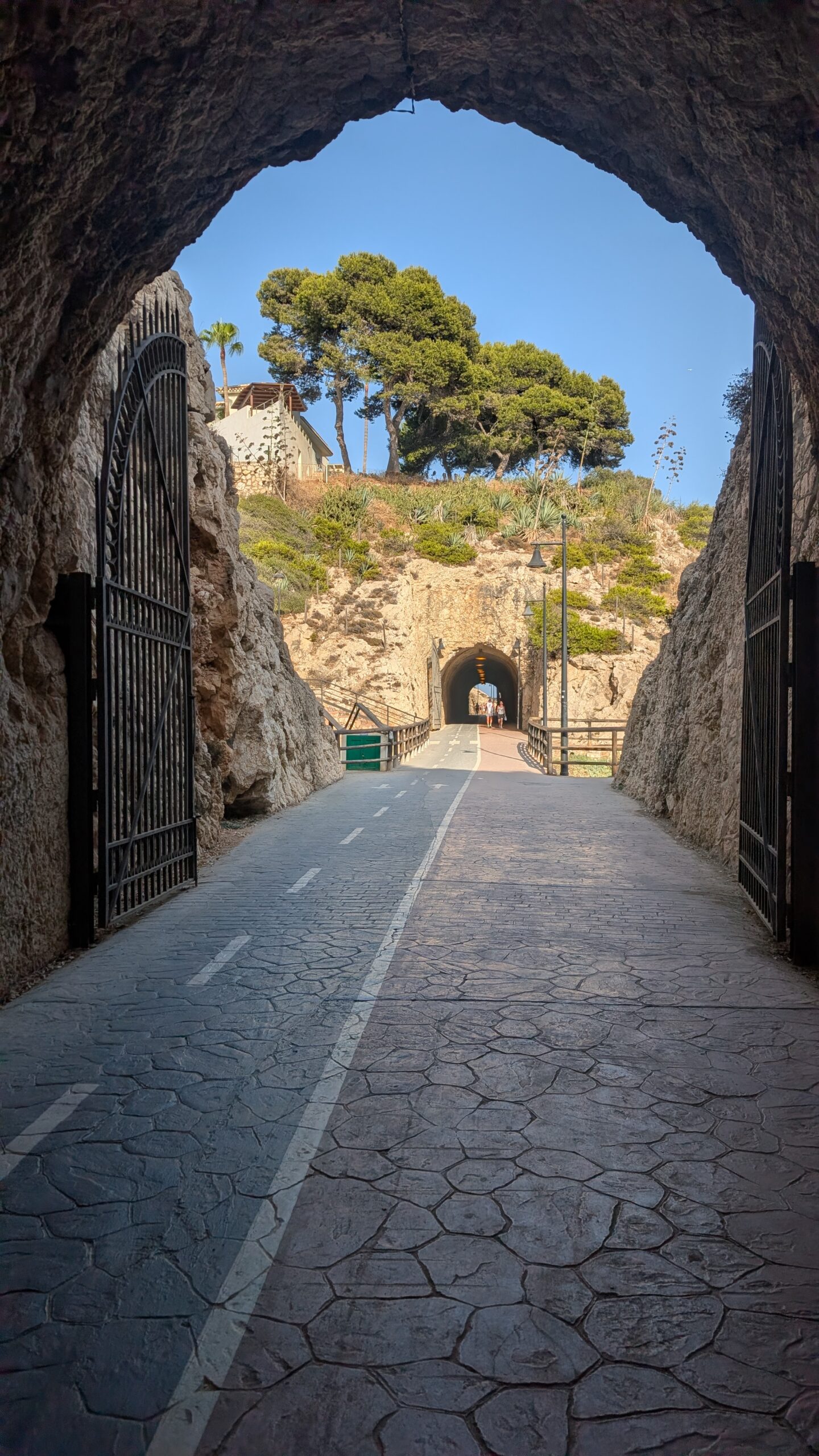 Looking out of a stone tunnel at a road ahead